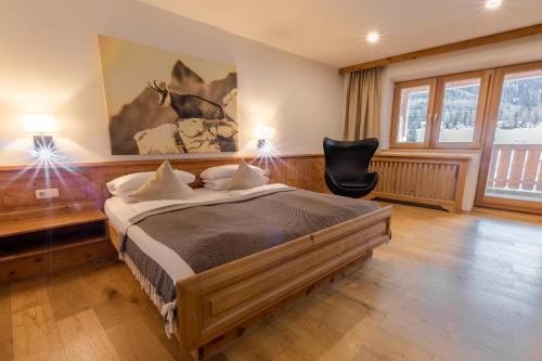 a bedroom with a bed and a chair in it at Monte Vita Tirol - Apartments in Biberwier