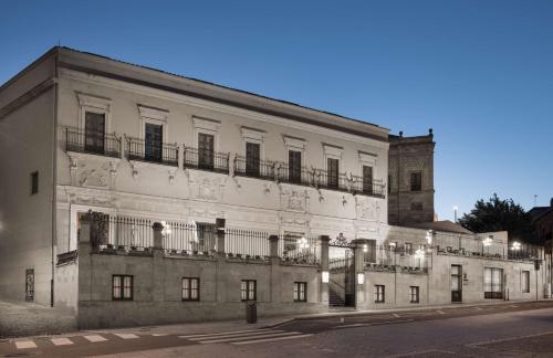 duży biały budynek z balkonami przy ulicy w obiekcie NH Collection Salamanca Palacio de Castellanos w Salamance