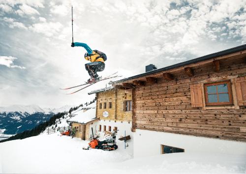 a skier jumping off the roof of a building at Berggasthaus & Lodge Resterhöhe in Mittersill