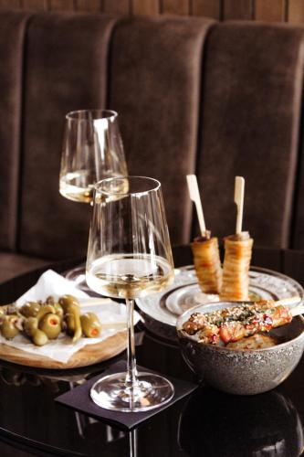 a table with two glasses of wine and a bowl of food at Minthis Resort in Paphos City