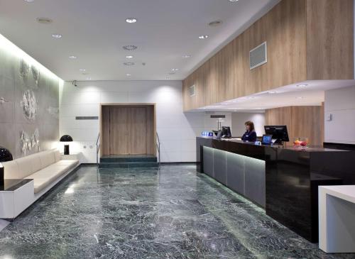 an office lobby with a woman sitting at a desk at NH Canciller Ayala Vitoria in Vitoria-Gasteiz