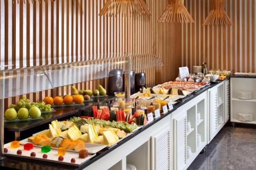 a buffet line with many different types of food at NH Canciller Ayala Vitoria in Vitoria-Gasteiz