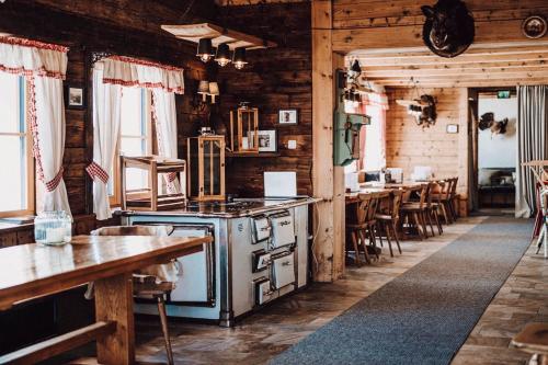 a kitchen with a stove and a table and chairs at Berggasthaus & Lodge Resterhöhe in Mittersill