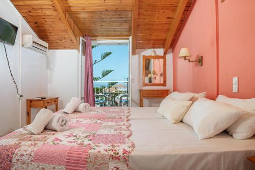 a bedroom with a bed with a view of the ocean at Chryssa Studios in Argasi