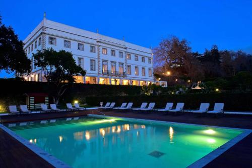a swimming pool in front of a building at night at Tivoli Palácio de Seteais Sintra Hotel - The Leading Hotels of the World in Sintra