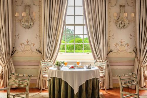 a dining room with a table and a window at Tivoli Palácio de Seteais Sintra Hotel - The Leading Hotels of the World in Sintra