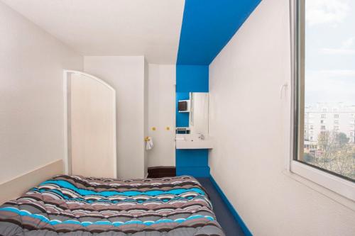 una camera con un letto in una stanza con finestra di hotelF1 Colmar Parc des Expositions a Colmar