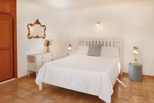 a bedroom with a white bed and a dresser and a mirror at Agroturisme Perola - Only Adults in Llucmajor