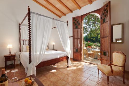 a bedroom with a canopy bed and an open door at Agroturisme Perola - Only Adults in Llucmajor