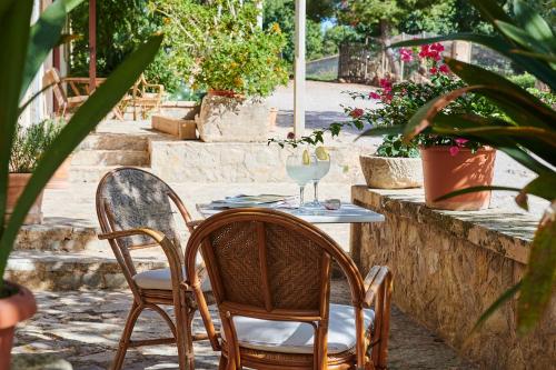 a table with two chairs and a wine glass at Agroturisme Perola - Only Adults in Llucmajor