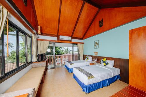 a bedroom with two beds and a balcony at Karona Resort & Spa - SHA Extra Plus in Karon Beach