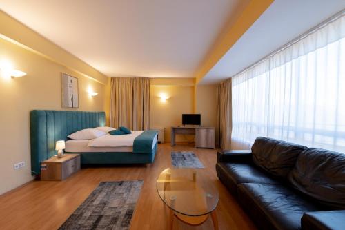 sala de estar con sofá y cama en Hotel Perla en Timisoara