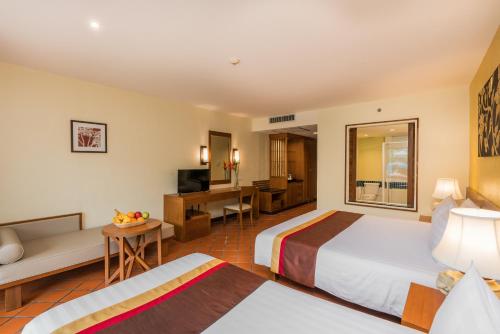 a hotel room with two beds and a desk at Naithonburi Beach Resort in Nai Thon Beach