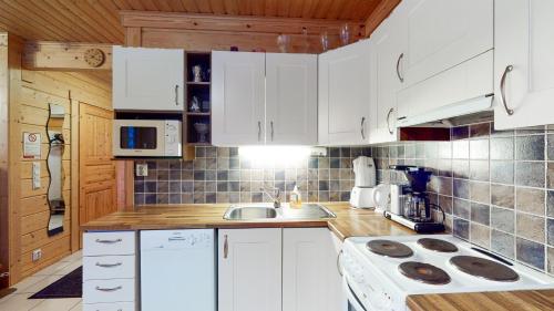 a kitchen with white cabinets and a sink at Himos Huili 2 in Himos