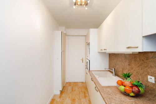 une cuisine avec un bol de fruits sur le comptoir dans l'établissement Super Californie YourHostHelper, à Cannes