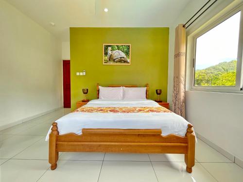 a bedroom with a large bed with a window at The Seaboards Apartments Seychelles in Mahe