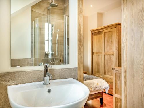 ein Badezimmer mit einem weißen Waschbecken und einer Dusche in der Unterkunft Daisy Cottage - Uk38683 in Oxhill