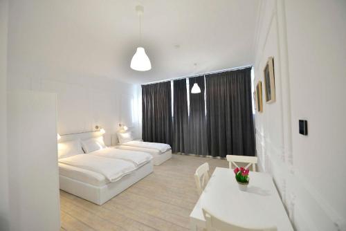 a white living room with a couch and a table at Otilia in Bucharest