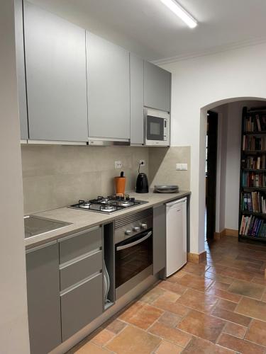 a kitchen with white cabinets and a stove top oven at Fazendinha - Tavira - Spacious and tranquil in Tavira