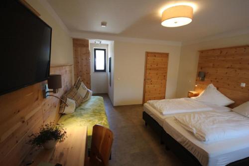 a bedroom with a bed and a flat screen tv at Gasthof Ehrl in Essing