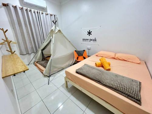 Home of Camper 659 in Seremban (16-18Pax) في سِريمبان: سرير مع خيمة في الغرفة