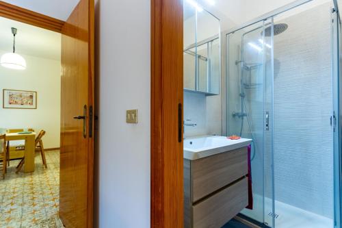ein Bad mit einem Waschbecken und einer Glasdusche in der Unterkunft Appartamento La Poesia Bilo 2 - MyHo Casa in Tortoreto Lido