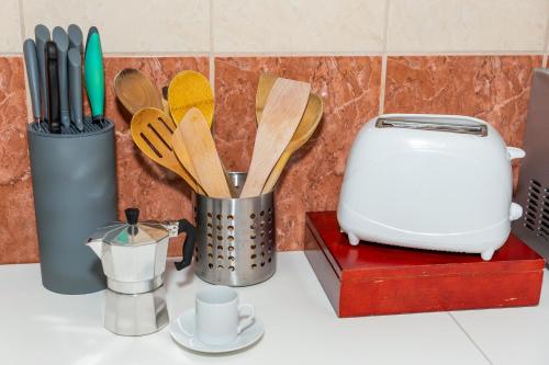 a counter top with a toaster and some wooden utensils at Wanderer 3 in Debrecen