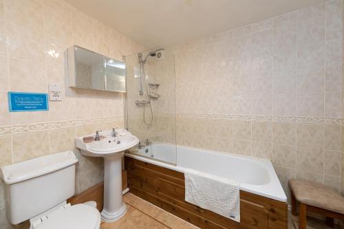 ein Badezimmer mit einem Waschbecken, einer Badewanne und einem WC in der Unterkunft Cobblestones Cottage at Lovelady Shield in Alston