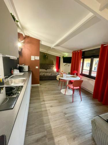 Una cocina con cortinas rojas y una mesa y sillas. en DEA DREAMS - Marghera WiFi Metro a 2 passi, en Milán