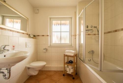 ein Bad mit einem Waschbecken, einem WC und einer Dusche in der Unterkunft Ferienwohnung Pilsensee in Herrsching am Ammersee