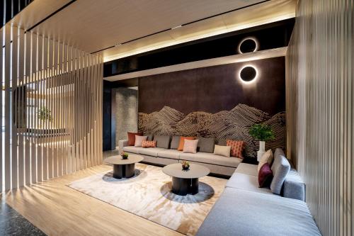 een woonkamer met een bank en 2 tafels bij base-Beijing Sanlitun Serviced Apartment in Beijing