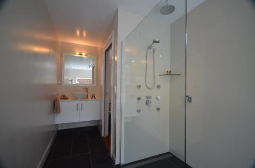 La salle de bains est pourvue d'une douche et d'un lavabo. dans l'établissement Cumberland Resort & Spa, à Burnt Pine