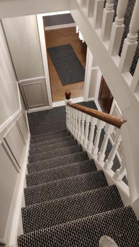 a winding staircase with black and white carpet at Brads Pad -Ballymena Central- in Ballymena