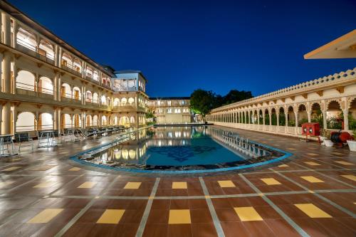 un patio con piscina en el centro de un edificio en Holiday Resort & Spa A Unit of S Poddar Group, en Gandhidham