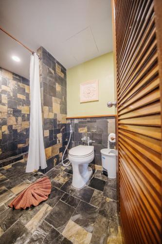 a bathroom with a toilet and a shower at Karona Resort & Spa - SHA Extra Plus in Karon Beach