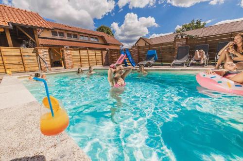a group of people playing in a swimming pool at Apartments Galunder in Veržej