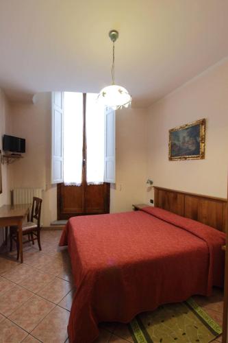 a bedroom with a red bed and a table at Hotel Margaret in Florence