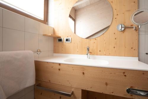 ein Bad mit einem Waschbecken und einem Spiegel in der Unterkunft Pension Örtlerhof in Dorf Tirol