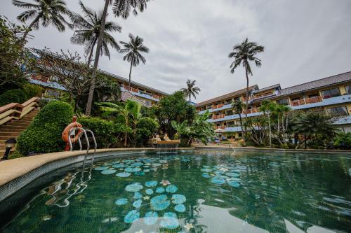 una persona sentada en una piscina en un complejo en Karona Resort & Spa - SHA Extra Plus, en Karon Beach