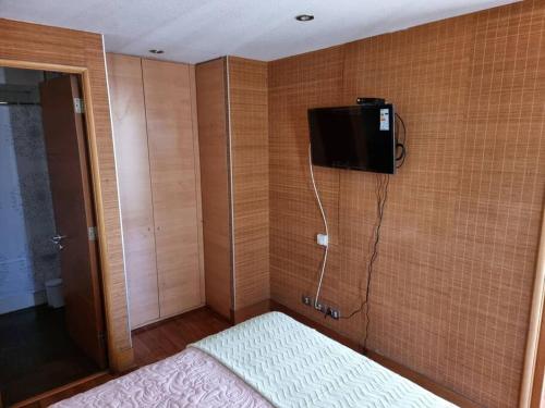 ein Schlafzimmer mit einem TV an der Ecke einer Wand in der Unterkunft Dpto Metro Pedro de Valdivia, Costanera Center in Santiago