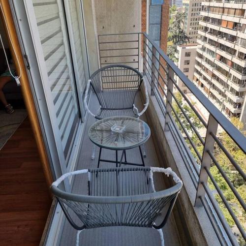 einen Tisch und einen Stuhl auf dem Balkon in der Unterkunft Dpto Metro Pedro de Valdivia, Costanera Center in Santiago