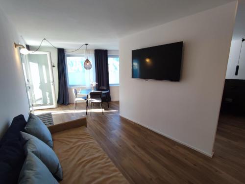 a living room with a couch and a television on a wall at VistaLago Torbole in Nago-Torbole