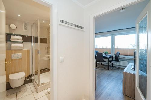 een badkamer met een douche, een toilet en een tafel bij Beachlife in Westerland