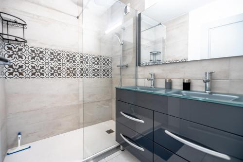 普朗德拉圖爾的住宿－Superbe Appartement avec Piscine，一间带玻璃淋浴和水槽的浴室
