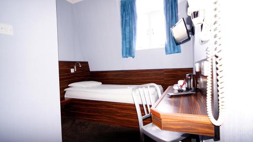 a small room with a bed and a desk at Crestfield Hotel in London