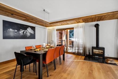 a dining room with a table and chairs and a fireplace at Chalet Larchwood by Mrs Miggins in Grimentz
