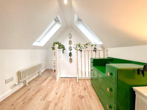 a green dresser in a room with skylights at Stunning Loft Apartment South Queensferry High St Bridge Views! in Queensferry