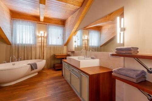 een badkamer met een bad, een wastafel en een bad bij Ski Dome Apartments & Heaven Holiday Chalet in Kaprun