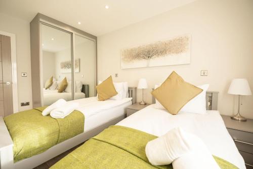 a bedroom with two beds and a mirror at Chester House in Reading