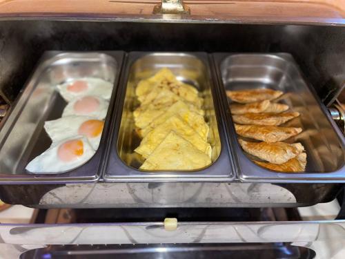 a tray of breakfast food with eggs and pastries at Edem Hotel Lviv in Lviv